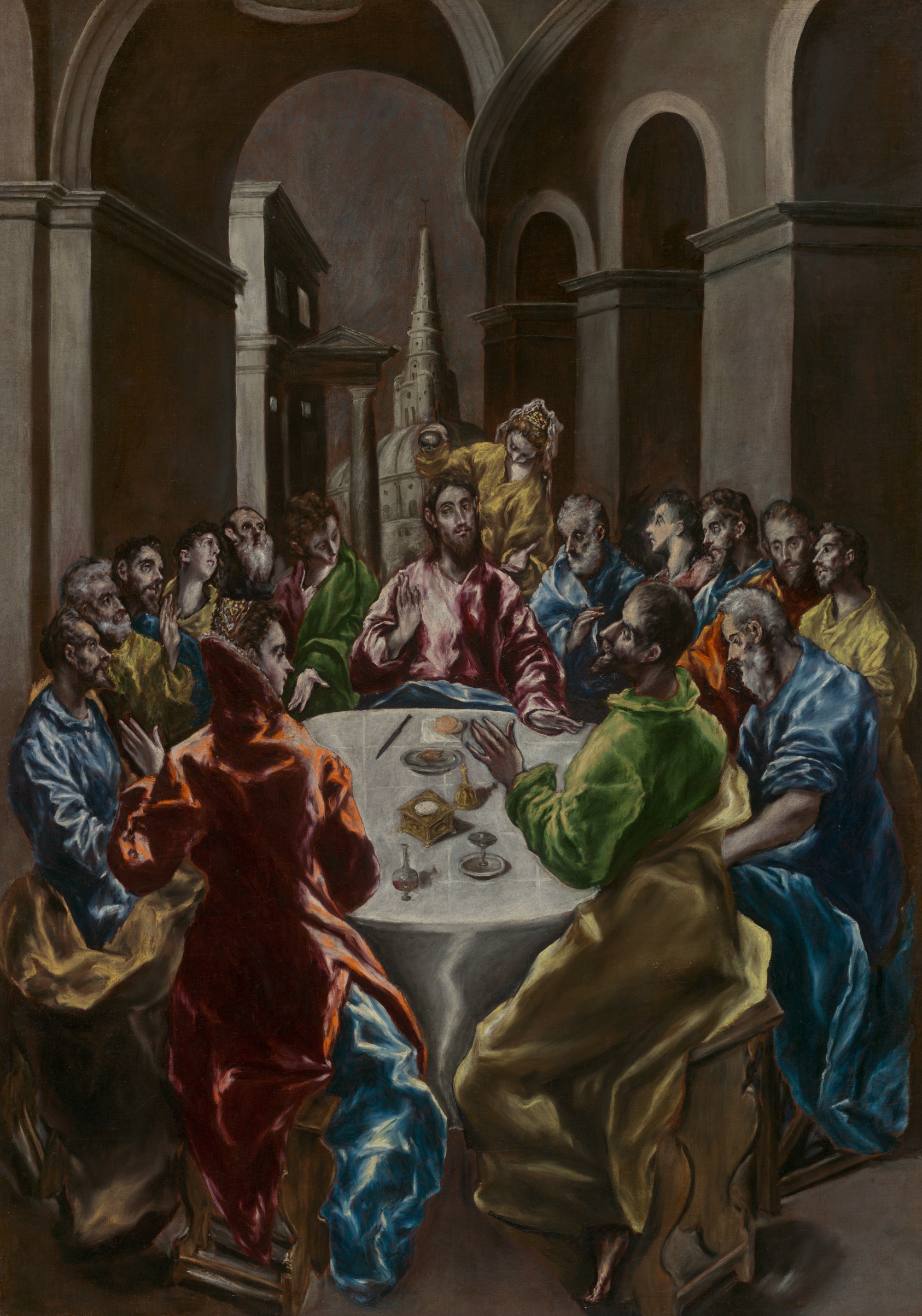 Painting depicting Christ anointed by a woman in yellow, seated centrally at a crowded table of guests with long thin grayish faces in colorful robes with strong white highlights. In the background, tall grey archways, a steepled building, and city architecture.