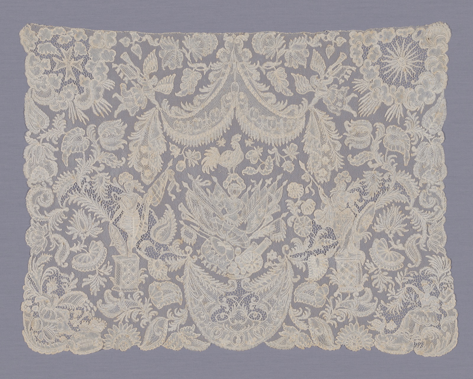 A rectangular piece of cream-colored lace fabric boasts a complex design that includes flowers, leaves, roosters, trumpeting angels, armed female warriors, and more.