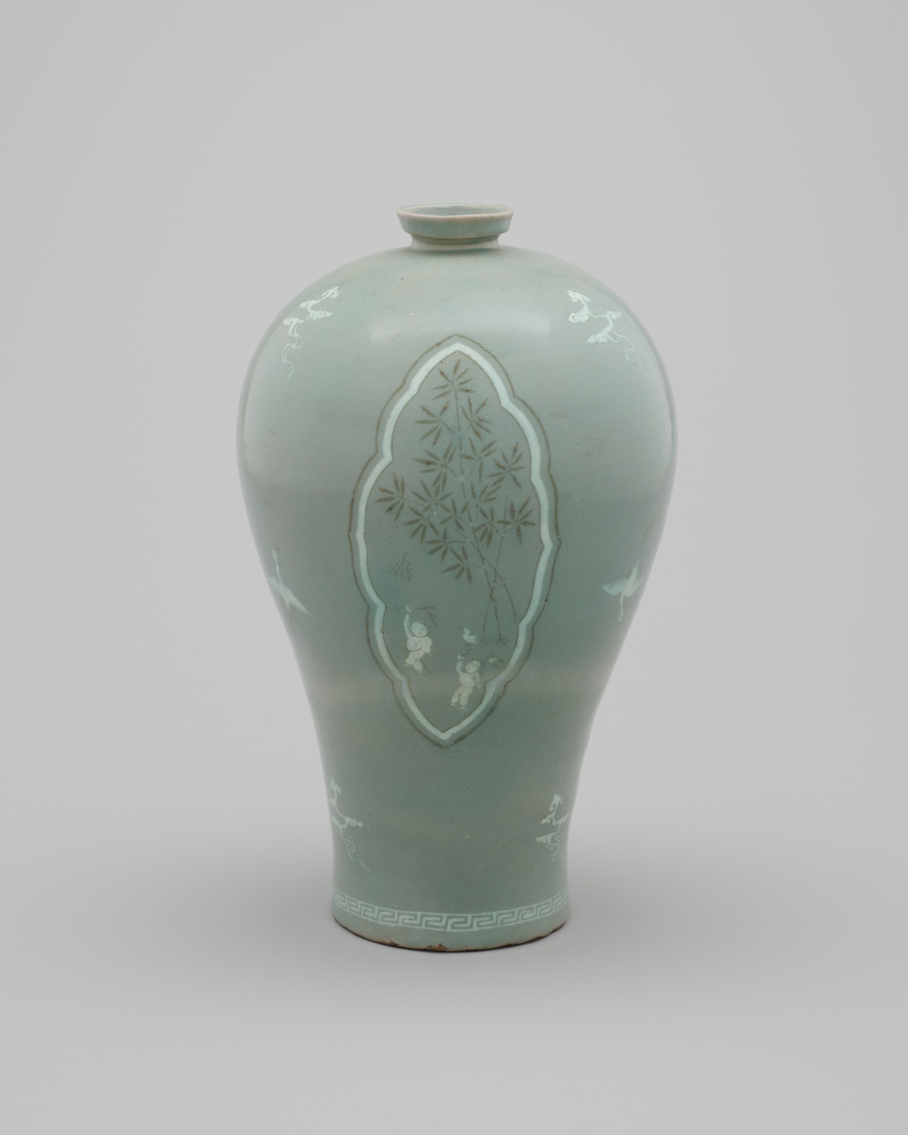 Pale green vase decorated with clouds, cranes,  and children playing near bamboo trees.