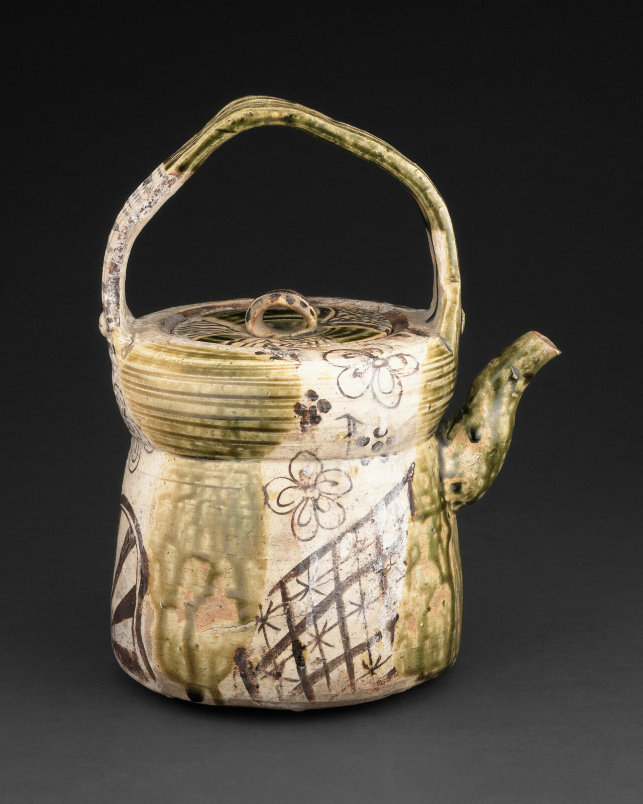 Greenish brown ceramic kettle with floral and geometric designs.